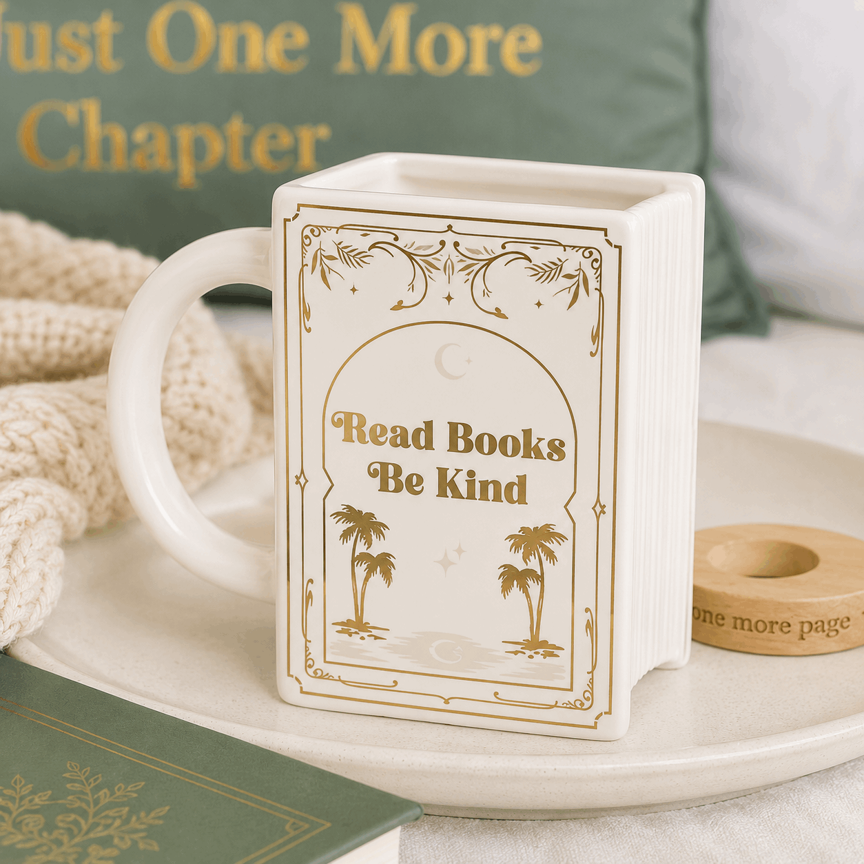 Mug with 'Read Books Be Kind' design on a surface with books and a candle.