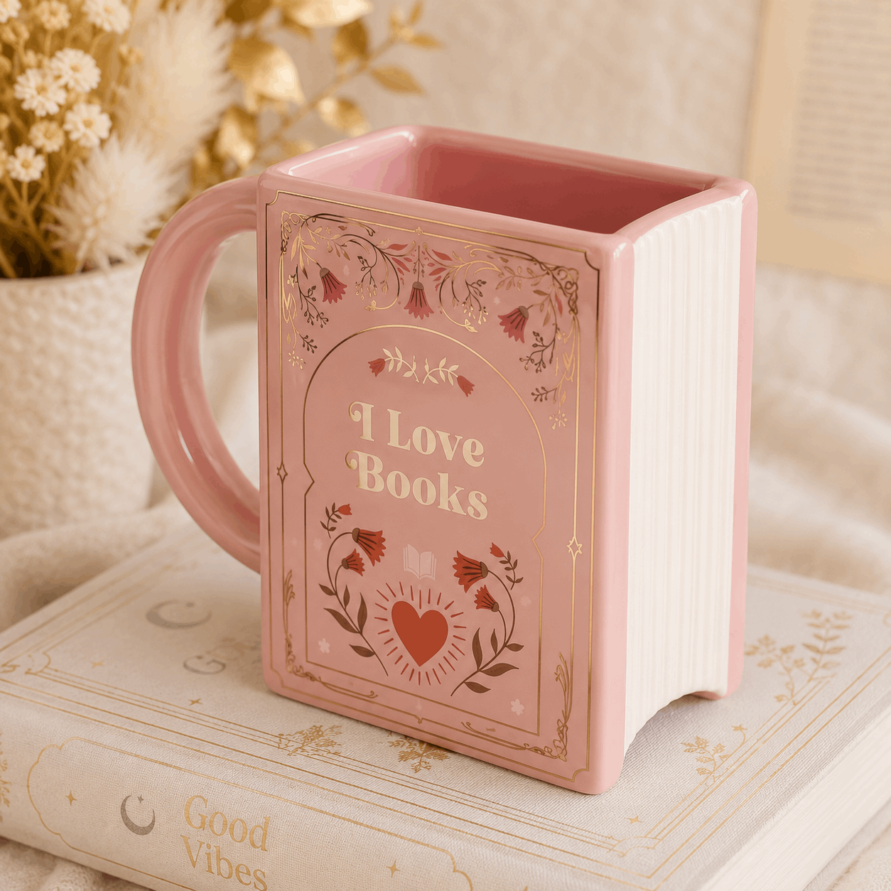 Pink mug designed like an open book with 'I Love Books' text on a soft surface.