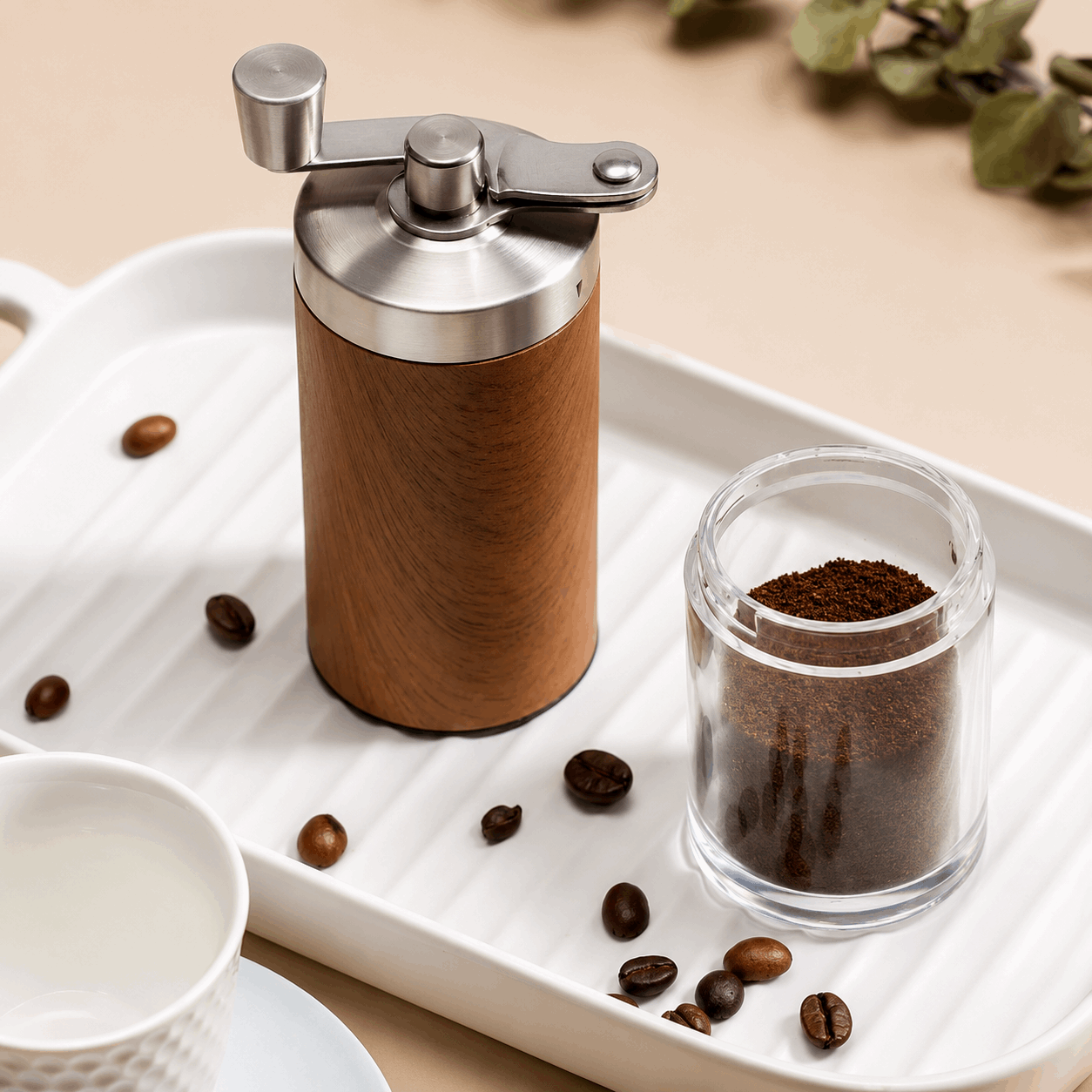 Wooden coffee grinder with ground coffee on a white tray