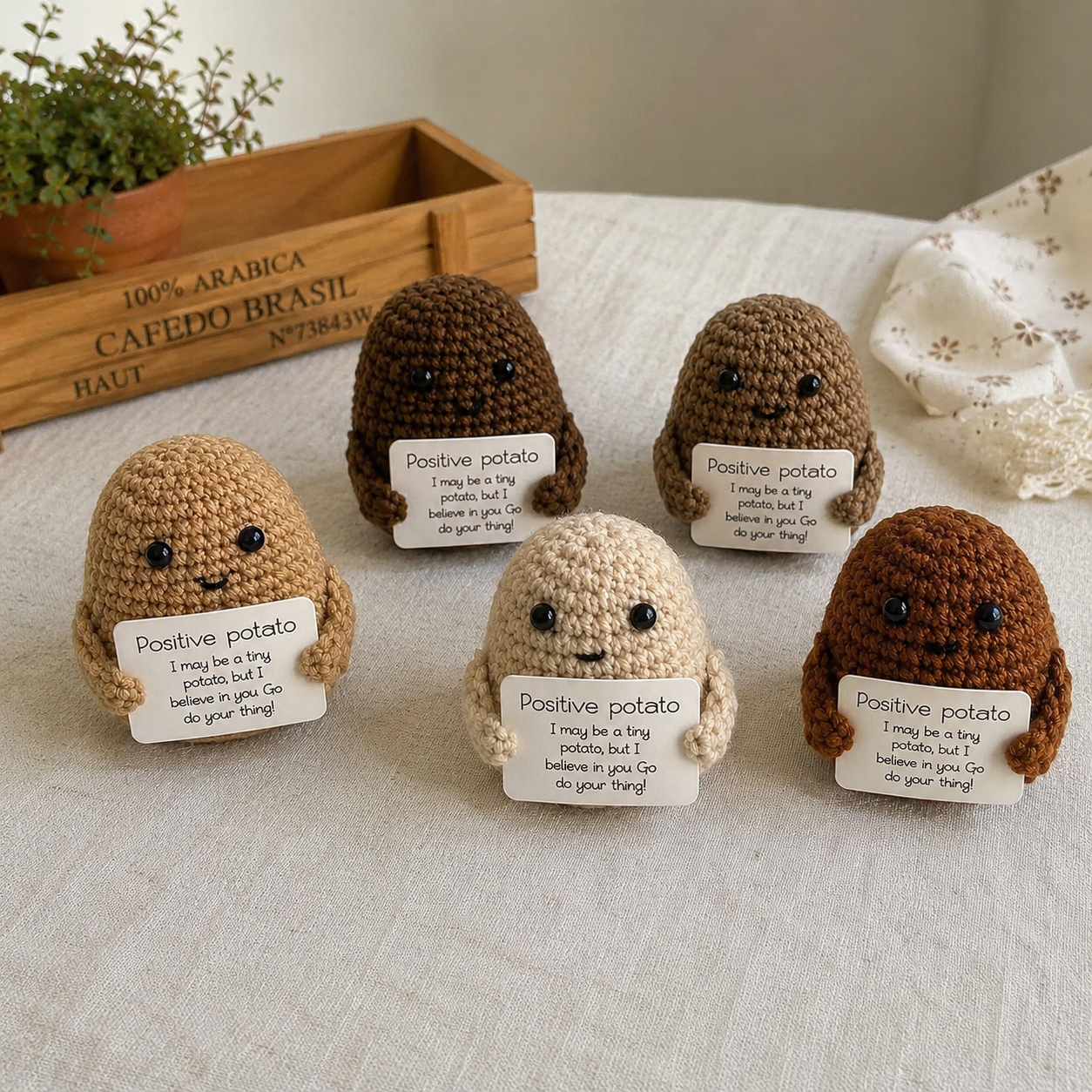Five crochet potato characters with 'positive potato' signs on a light surface.