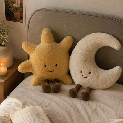 Sun and moon plush toys on a bed with a warm and cozy atmosphere.