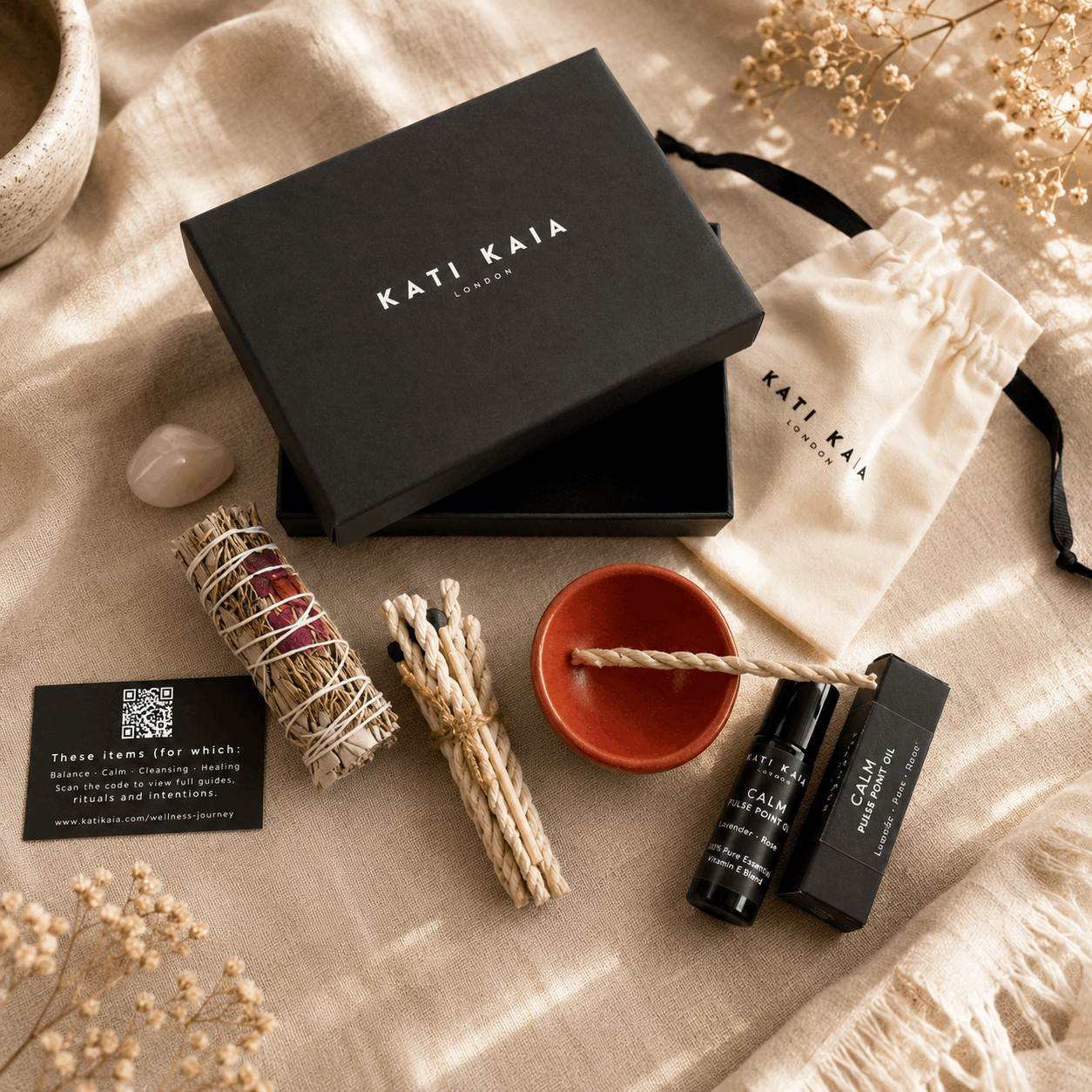 Kati Kaia products including a black box, incense sticks, a bowl, and a bottle on a textured surface.