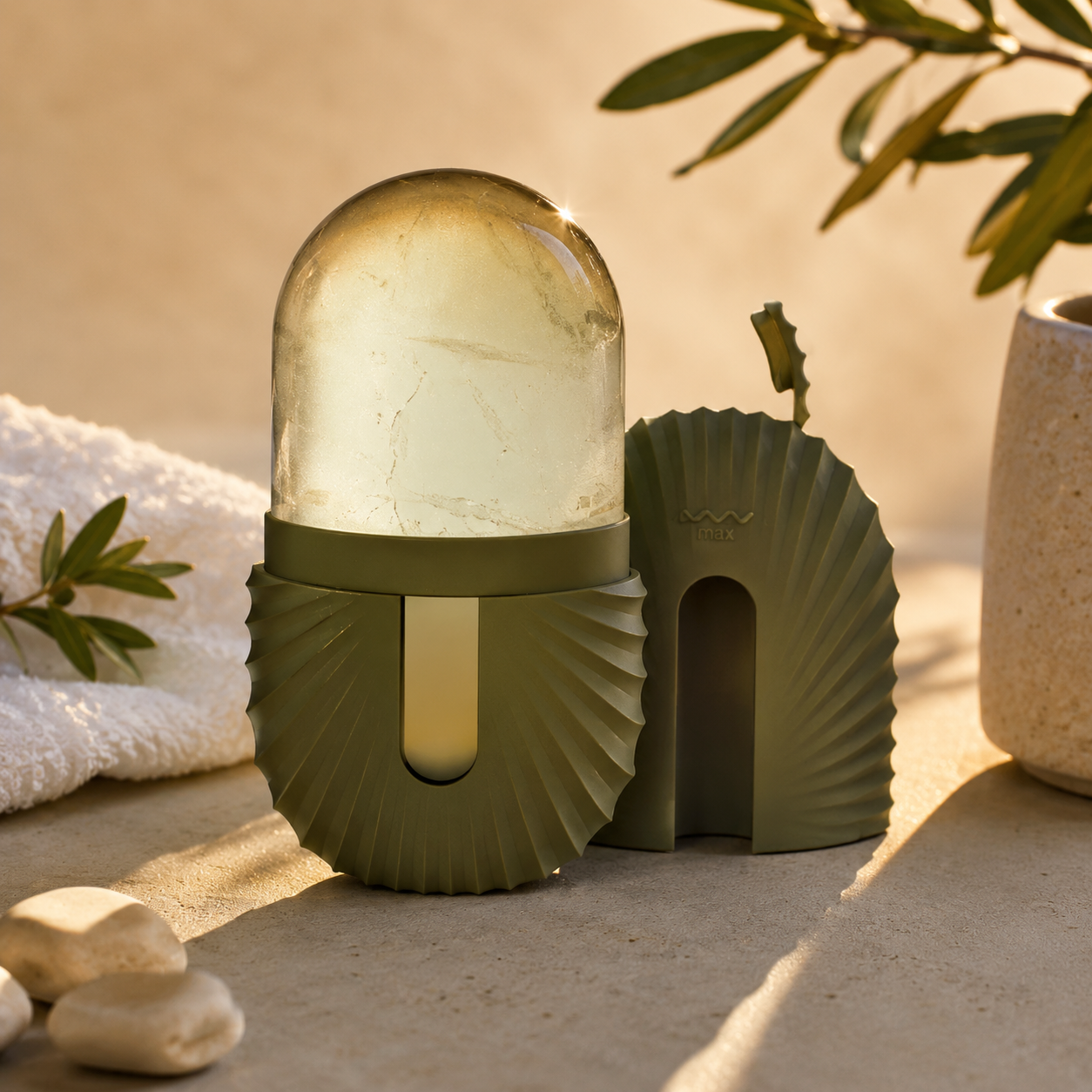 Decorative outdoor lamp with shell design on a sandy surface with plants and stones.