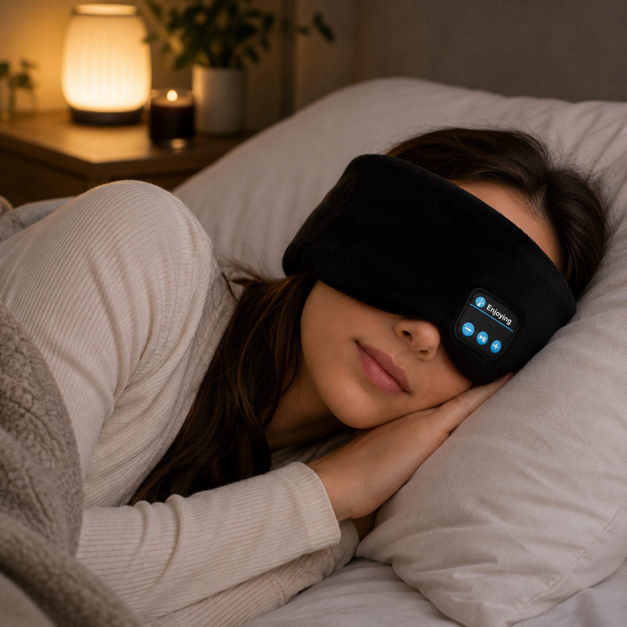 Woman wearing a black sleep mask with blue lights in bed at night.