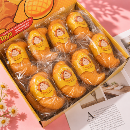 Packaged croissants with lion design in a box on a pink background