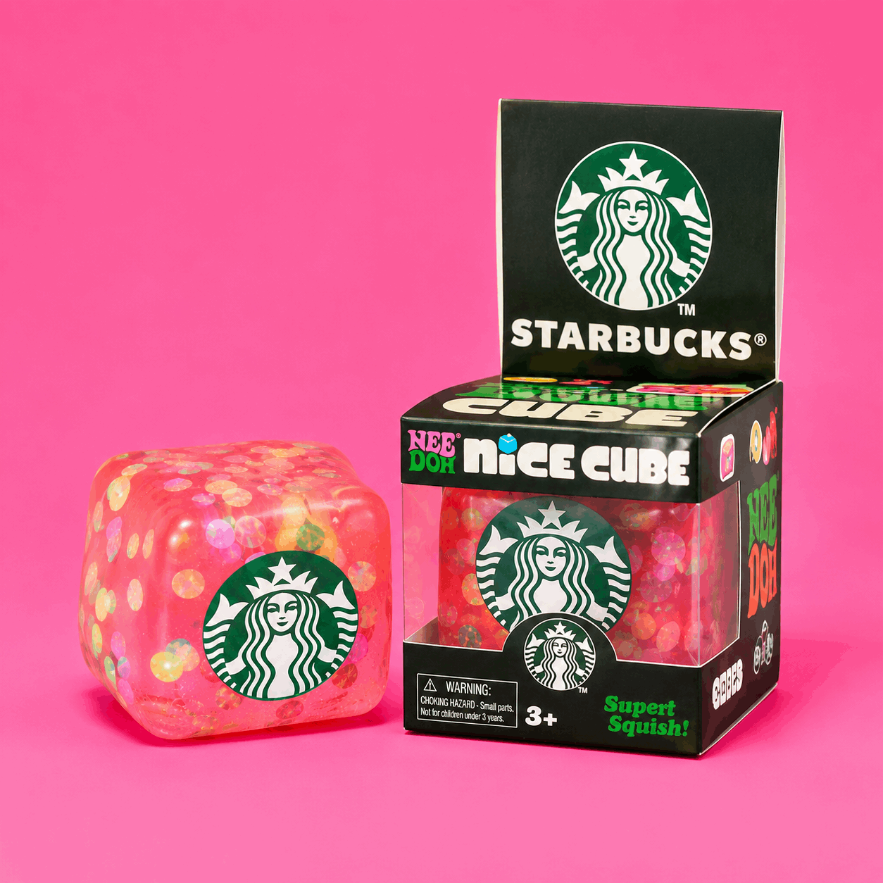 Starbucks-themed gummy cube with packaging on a pink background