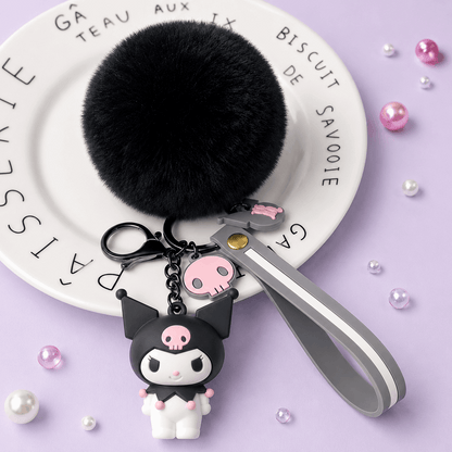 Keychain with black pom-pom, cartoon character, and pink heart on a purple background