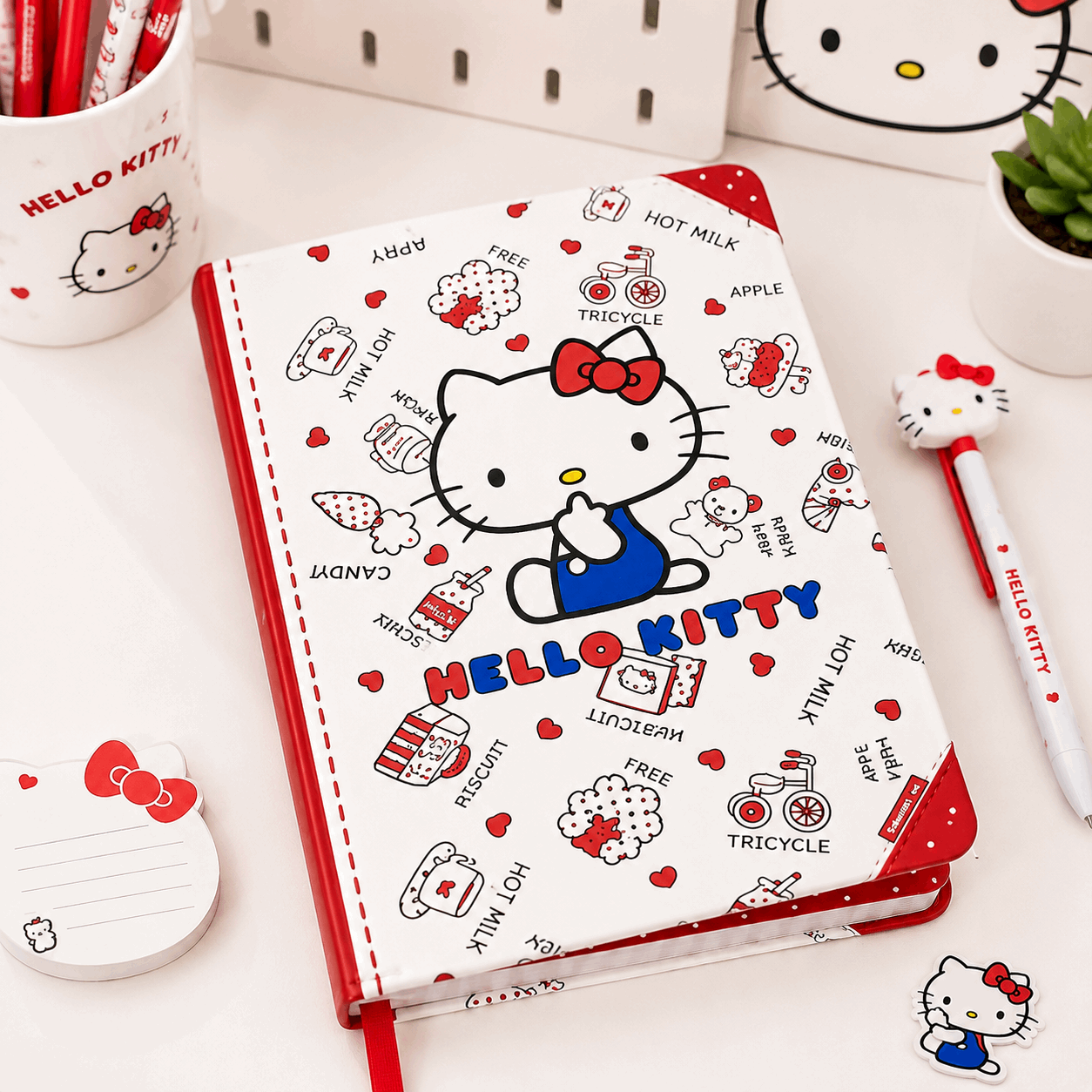 Hello Kitty notebook with stationery items on a white surface