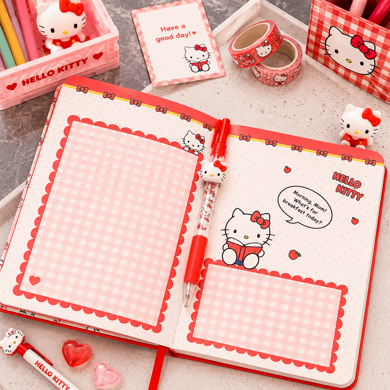 Hello Kitty-themed stationery set including notebook, pen, and decorative items on a light surface.