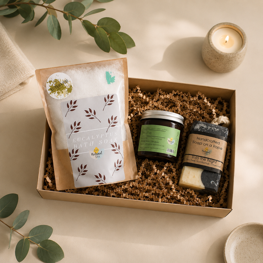 Gift box with natural products including soap, candle, and packaging on a light background