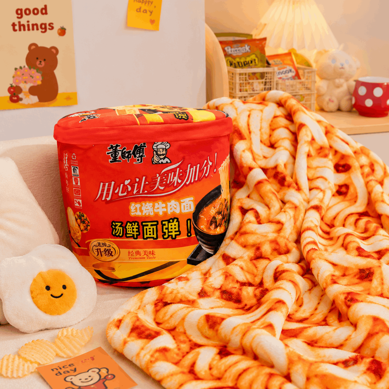 Noodle container with a plush noodle blanket on a couch, surrounded by decorative items.