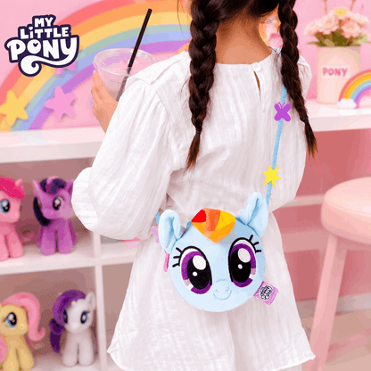 Child holding a My Little Pony-themed bag in a colorful room with toys and decorations.