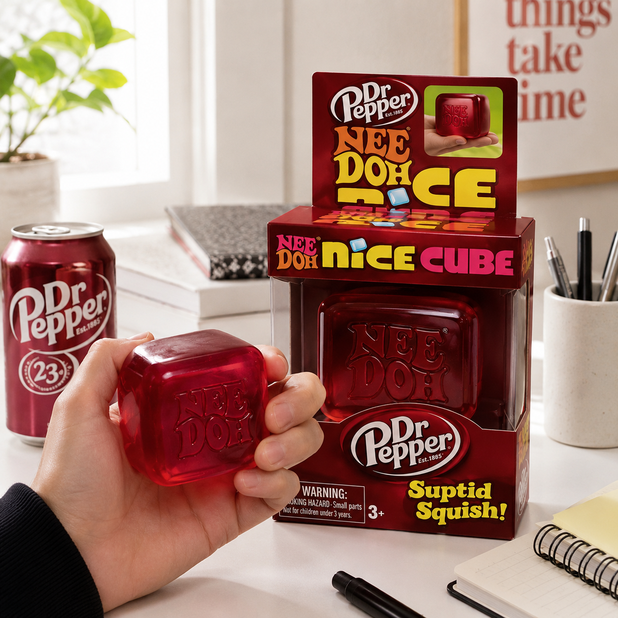 Dr Pepper Nee Doh Nice Cube toy held by a hand with packaging in the background