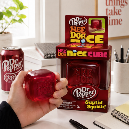 Dr Pepper Nee Doh Nice Cube toy held by a hand with packaging in the background