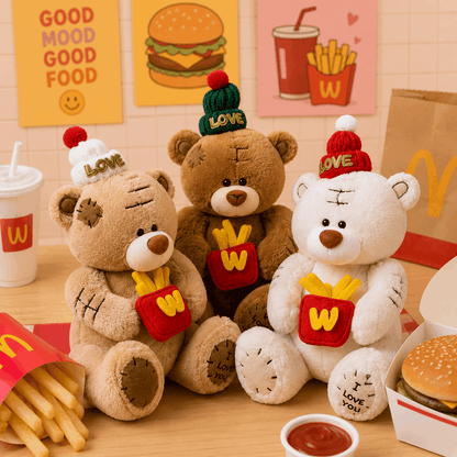 Three teddy bears with McDonald's-themed hats and outfits on a table with fast food items.