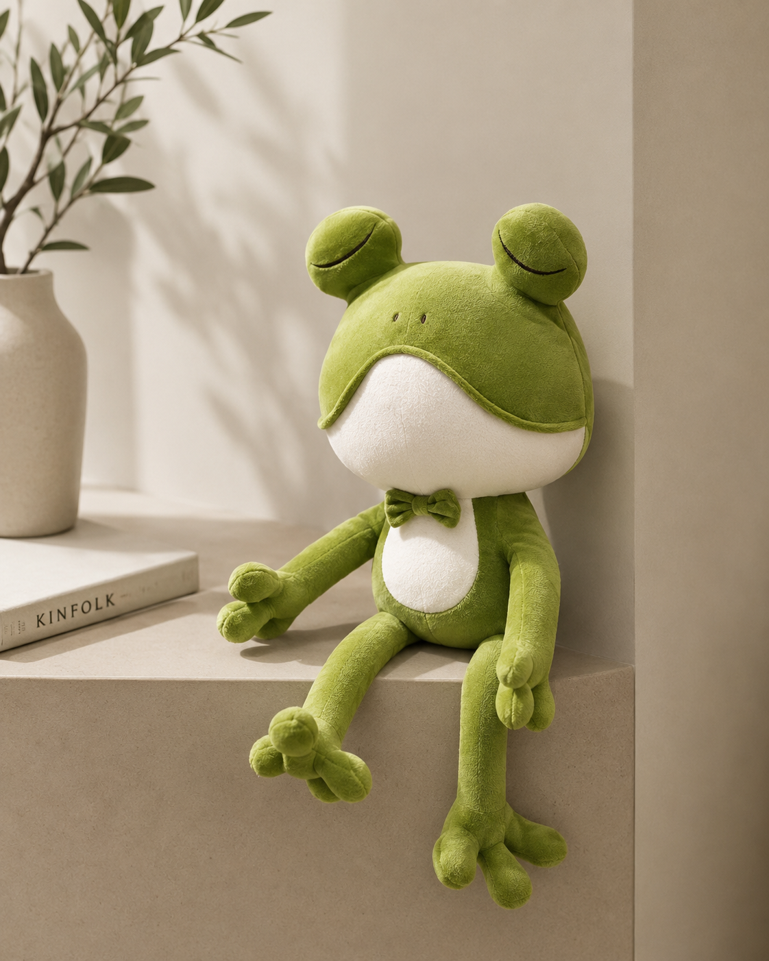Green plush frog toy sitting on a surface with a neutral background