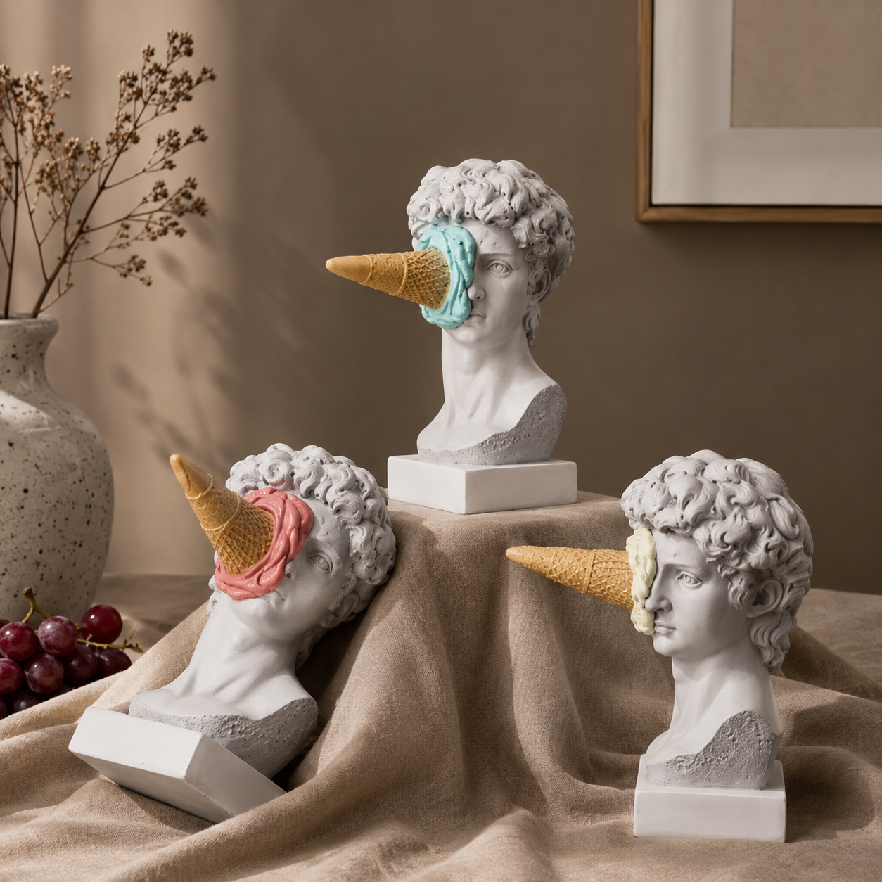 Decorative busts with ice cream cone heads on a draped surface.