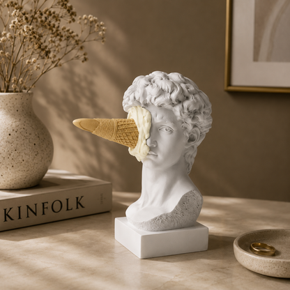 Statue head with ice cream cone on a table next to a 'KINFOLK' book