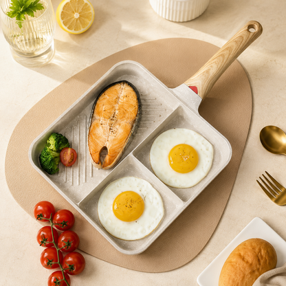 Divided pan with salmon and eggs on a table with vegetables and bread.