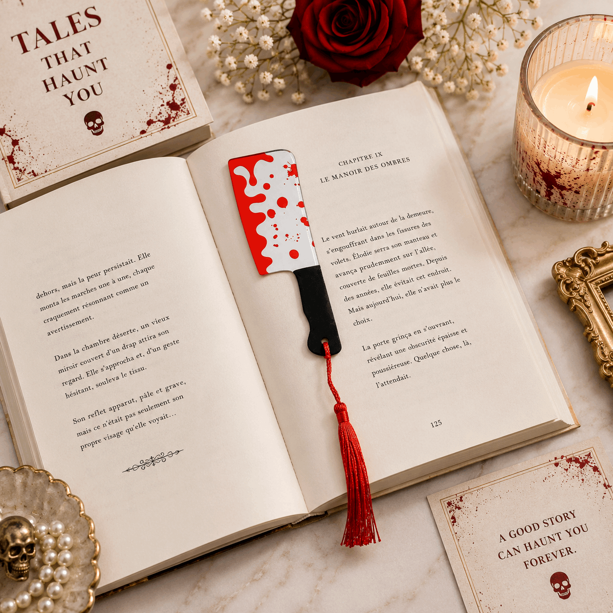 Open book with a bloody knife bookmark on a marble surface with a candle and decorative items.