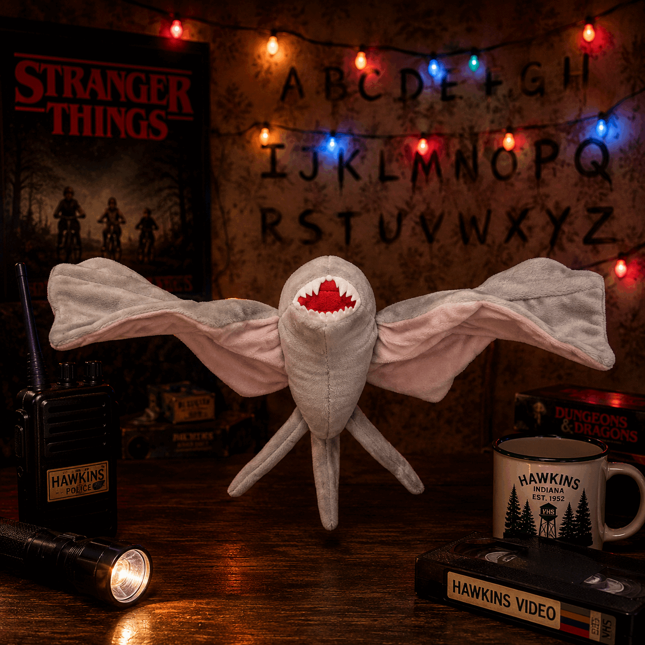 Stranger Things-themed plush toy with decorative lights and props on a wooden surface.