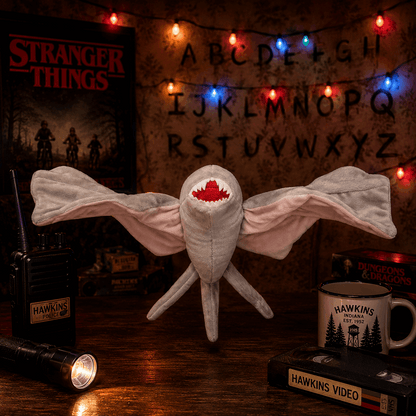 Stranger Things-themed plush toy with decorative lights and props on a wooden surface.