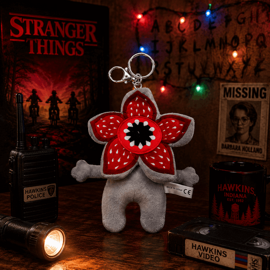 Stranger Things-themed keychain with red flower design on a wooden surface with props.
