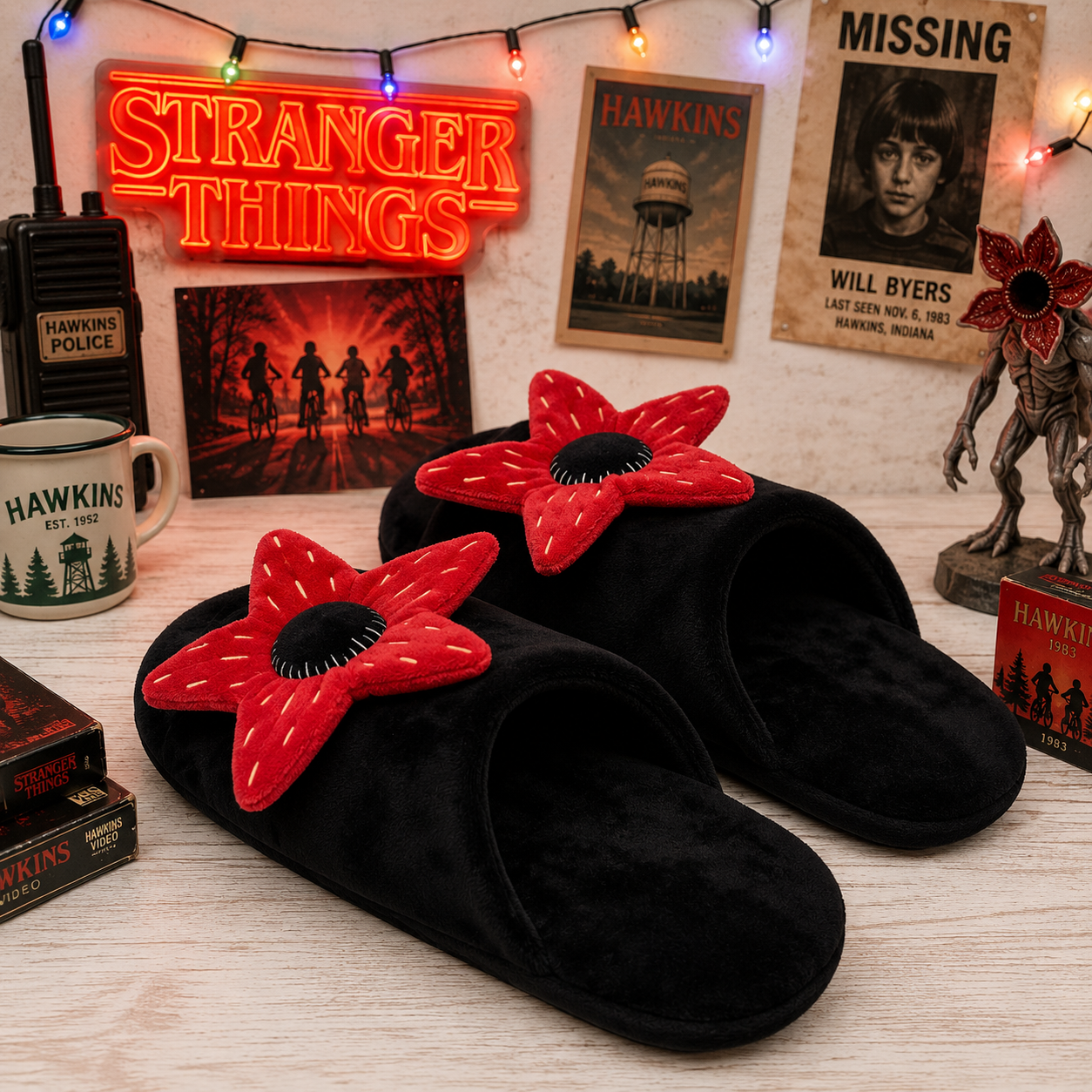 Black slippers with red flower designs on a surface with 'Stranger Things' themed decor.