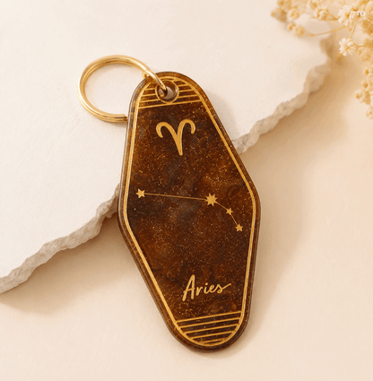 Keychain with Aries zodiac symbol on a beige background