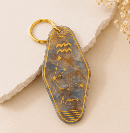 Keychain with Aquarius zodiac design on a beige background