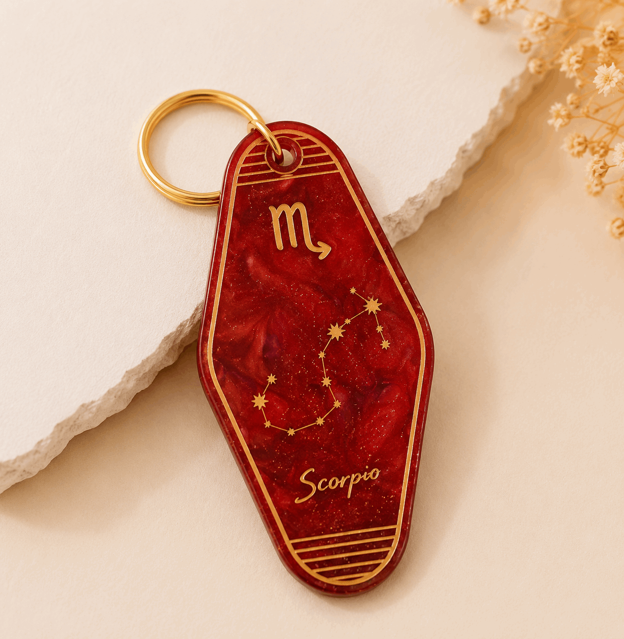 Red keychain with Scorpio zodiac symbol on a light background
