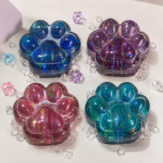 Four colorful paw-shaped containers on a white surface with decorative elements.