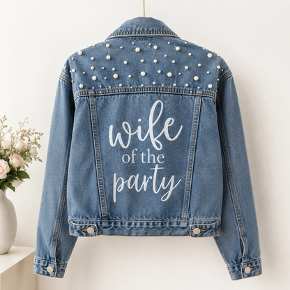 Blue denim jacket with pearl embellishments and 'wife of the party' text on a white background