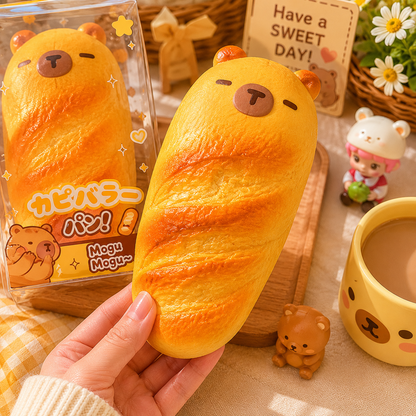 Yellow bear-shaped bread plush toy held by a hand with a 'Have a SWEET DAY!' sign in the background.