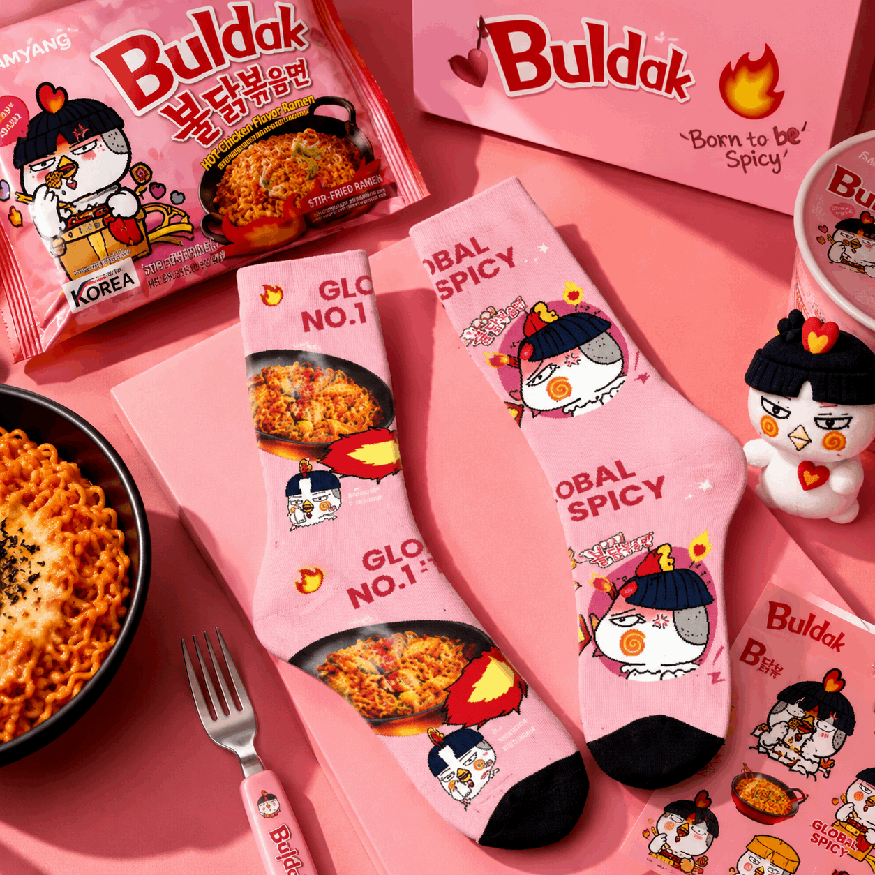 Pink socks with cartoon character design on a pink background, featuring the brand 'Buldak'.