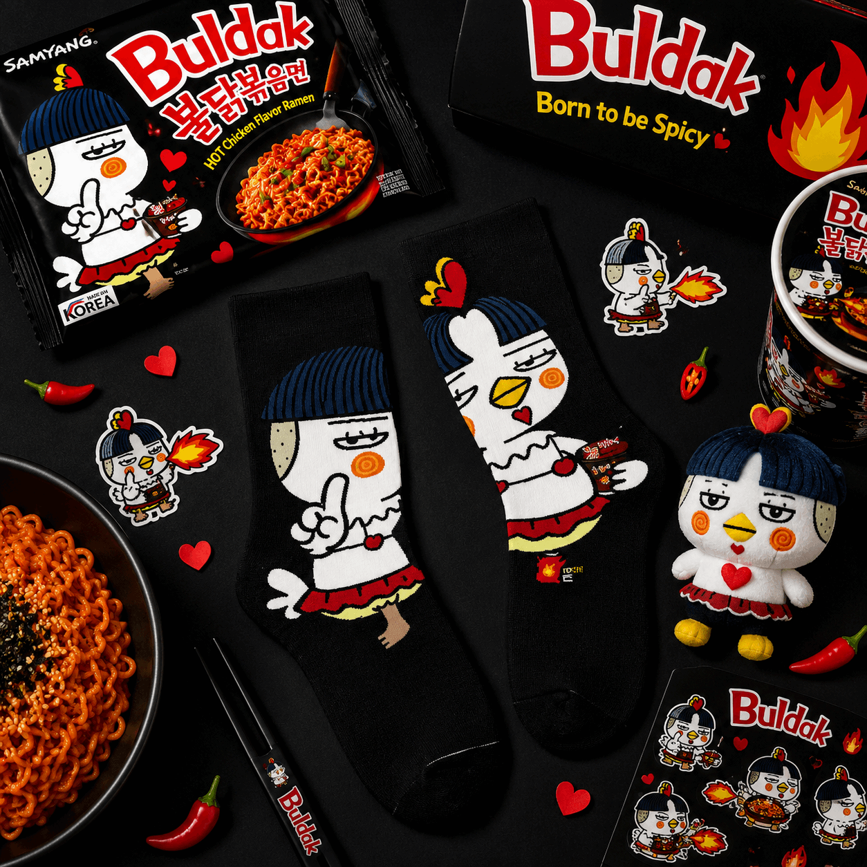 Buldak spicy noodle packaging with cartoon character, socks, and mug on a black background
