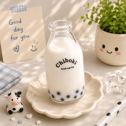 Glass bottle of milk with 'Chiboki' branding on a decorative plate, surrounded by a plant and a small cow figurine.