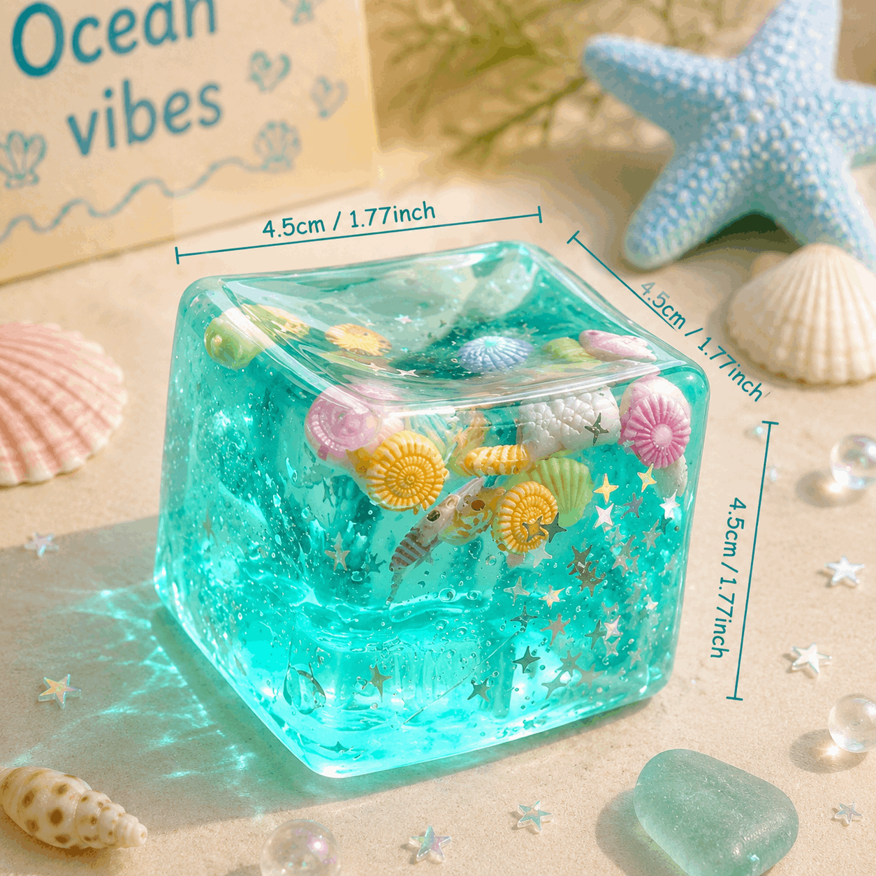 Clear resin cube with sea-themed decorations on a sandy background with 'Ocean vibes' text.