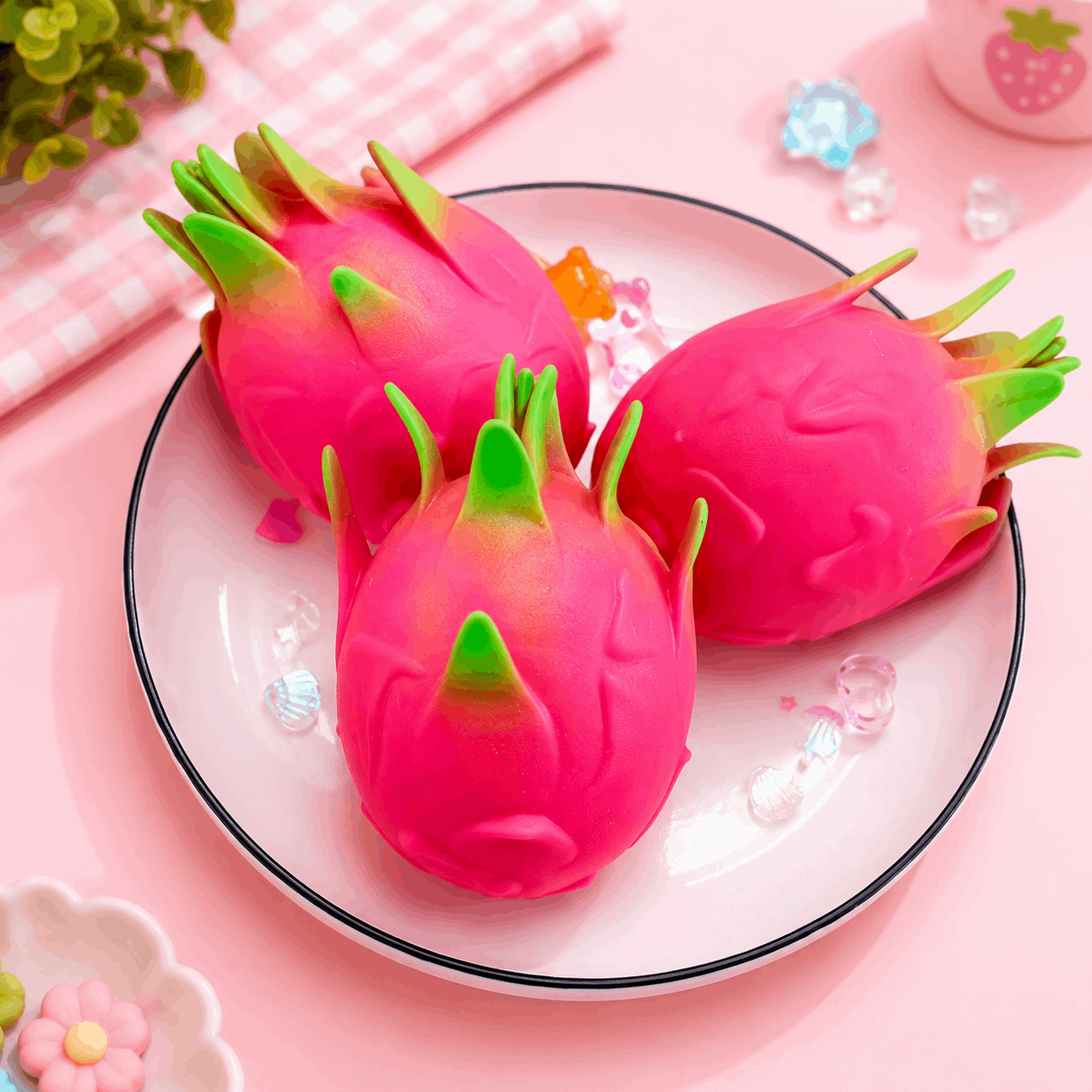 Pink dragon fruit-shaped items on a white plate with a pink background