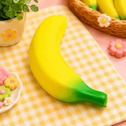 Yellow and green banana-shaped object on a checkered tablecloth with decorative elements.