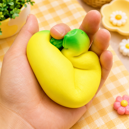 Hand holding a yellow and green stress ball with a checkered tablecloth in the background