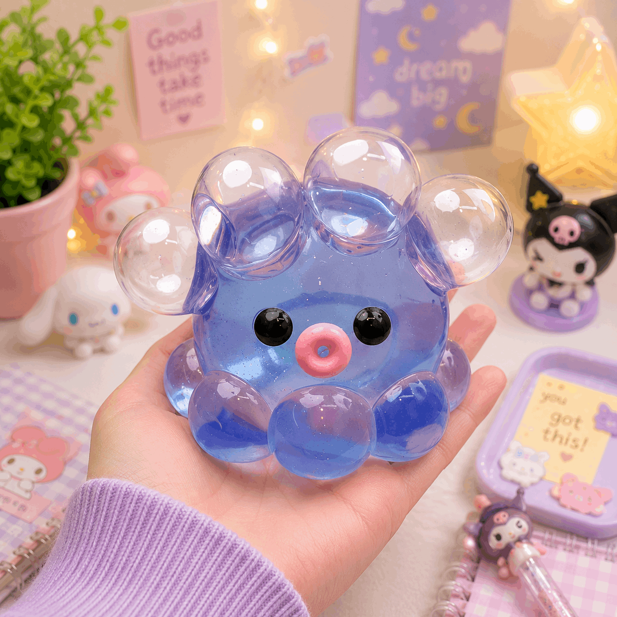 Cute blue character with transparent bubbles held in a hand against a colorful background