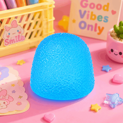 Blue textured lamp on a pink surface with decorative items and 'Good Vibes Only' sign.