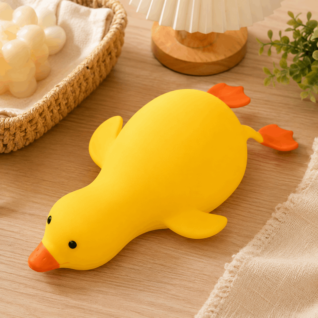 Yellow rubber duck toy on a wooden surface with decorative items in the background