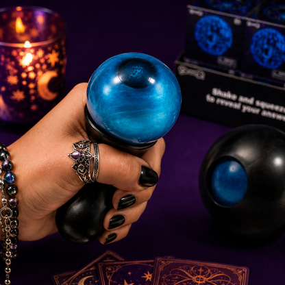 Hand holding a blue crystal ball with tarot cards and candles in the background