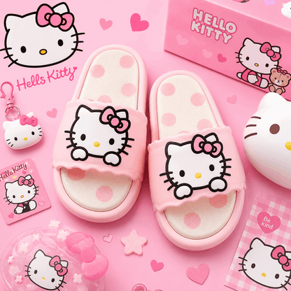 Pink Hello Kitty slide sandals with large Hello Kitty face graphics on the straps, shown with matching Hello Kitty packaging and accessories on a pink background.