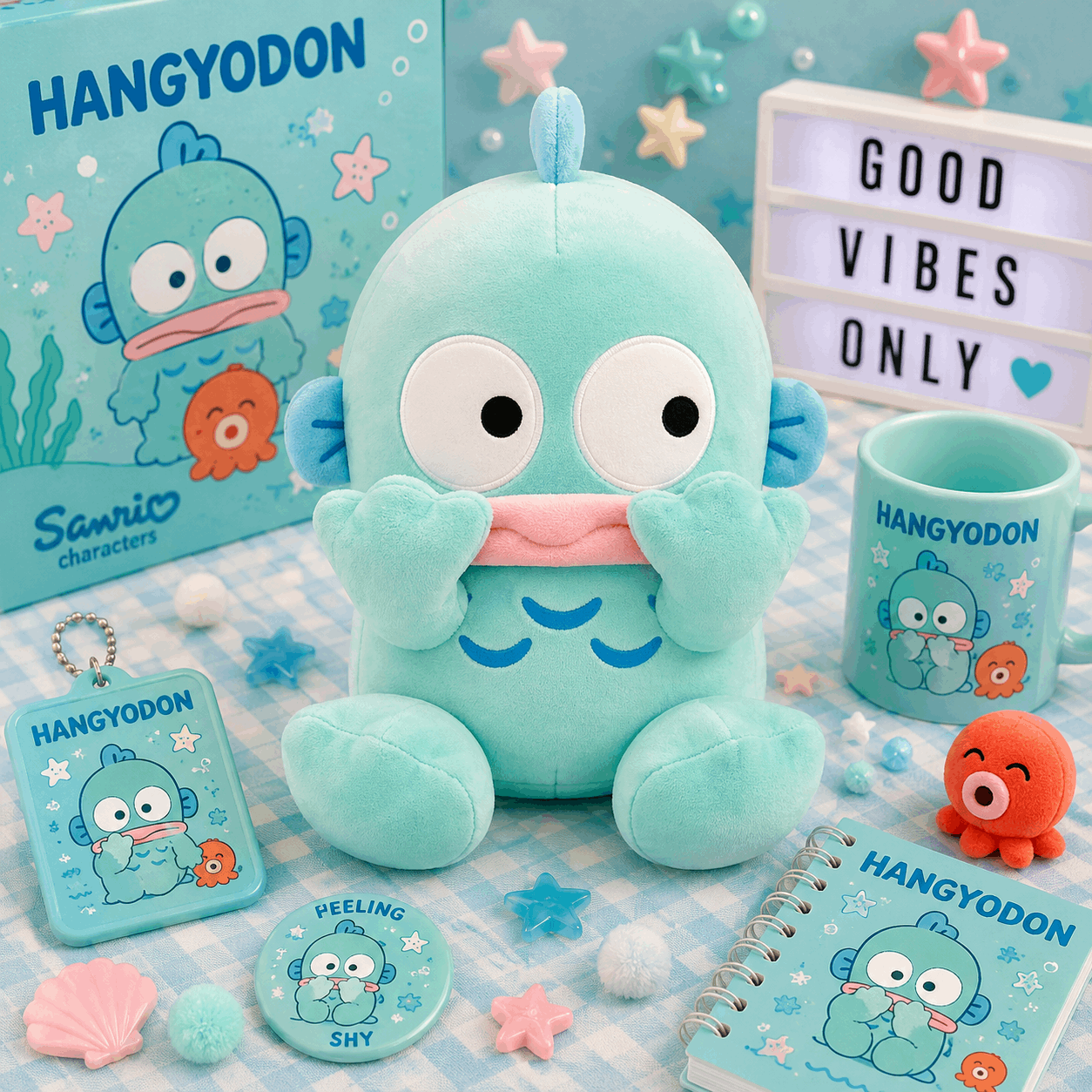 A Sanrio Hangyodon plush toy displayed with matching merchandise, including a mug, notebook, keychain, pin, and card, on a pastel blue and white checkered surface with star and pom-pom decorations.