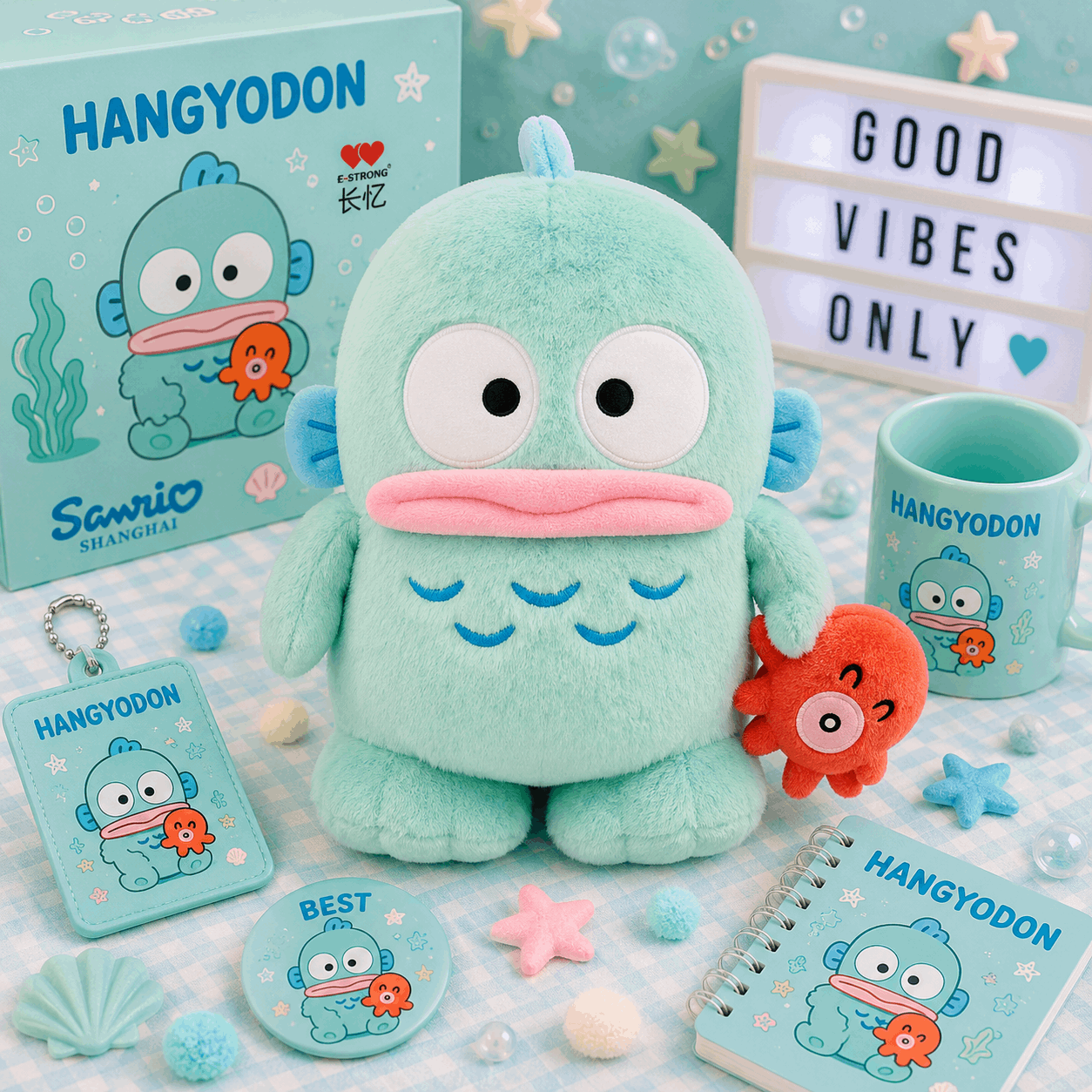 A Sanrio Hangyodon plush toy in mint green is displayed with its matching merchandise set, including a box, a mug, a notebook, a keychain, and a button badge, all featuring the blue and orange cartoon character on a light blue patterned background.