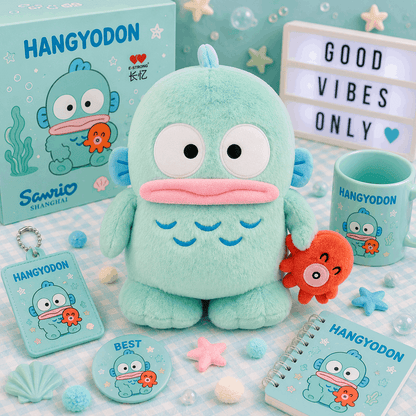 A Sanrio Hangyodon plush toy in mint green is displayed with its matching merchandise set, including a box, a mug, a notebook, a keychain, and a button badge, all featuring the blue and orange cartoon character on a light blue patterned background.