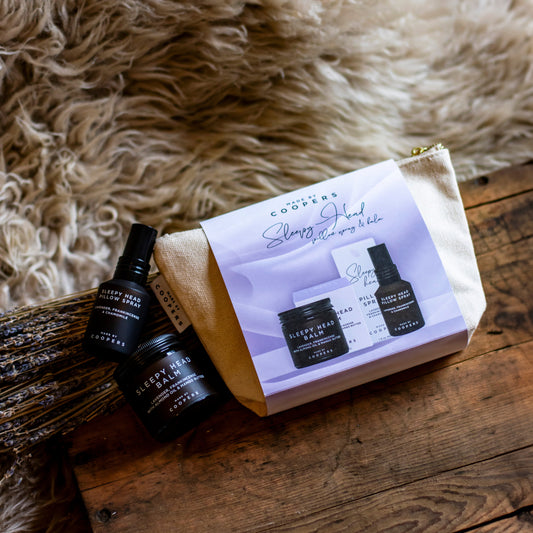 Set of beauty products including bottles and a pouch on a wooden surface with fur background